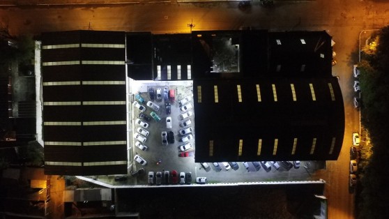 Os dois pavilhões e o estacionamento vistos de cima à noite