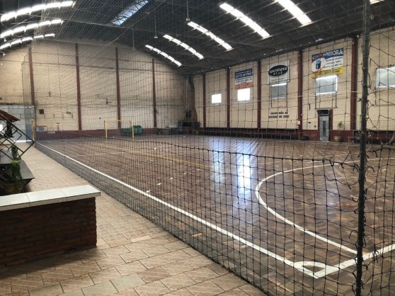 Quadra de futsal em parquet vista de dentro do ginásio